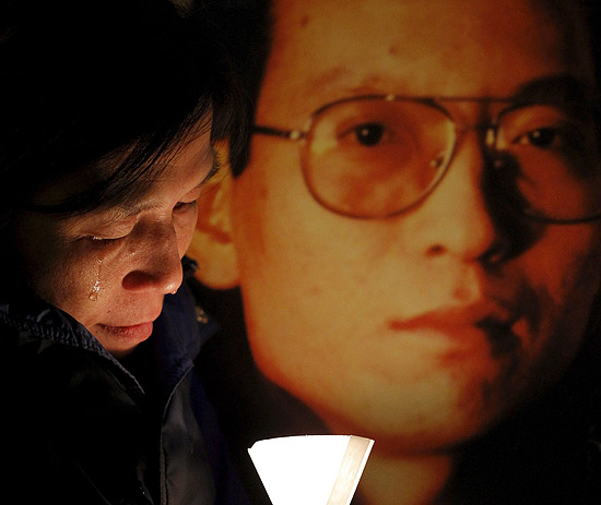 Mulher chora ao lado de foto de Liu Xiaobo, em vigilia por sua libertação em janeiro.