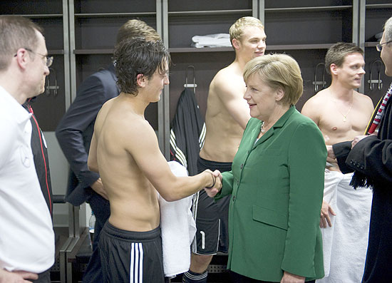 A chanceler (premi) da Alemanha, Angela Merkel, cumprimenta o jogador de origem turca Mesut zil aps jogo