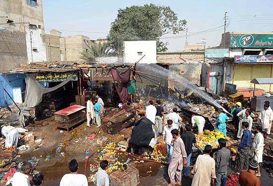 Moradores de Karachi, polo econmico paquistans, circulam por mercado atacado em uma onda de violncia