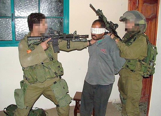Foto divulgada pela ONG israelense Quebrando o Silêncio mostra soldados de Israel apontando arma a palestino