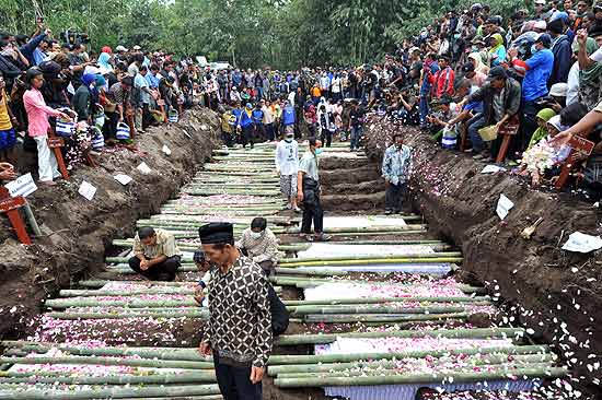 Parentes das centenas de mortos pelas tragédias na Indonésia participam de funeral coletivo na ilha de Java