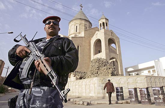 Imagem de arquivo mostra policial iraquiano em frente à igreja de Nossa Senhora da Salvação durante missa de Natal