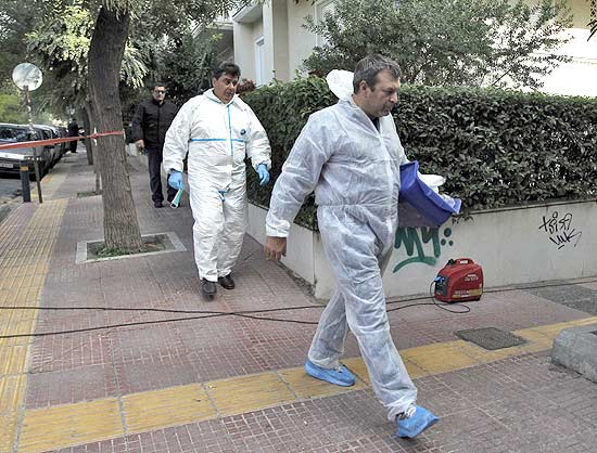 Investigadores deixam a Embaixada da Sua em Atenas, onde uma bomba explodiu hoje sem deixar feridos