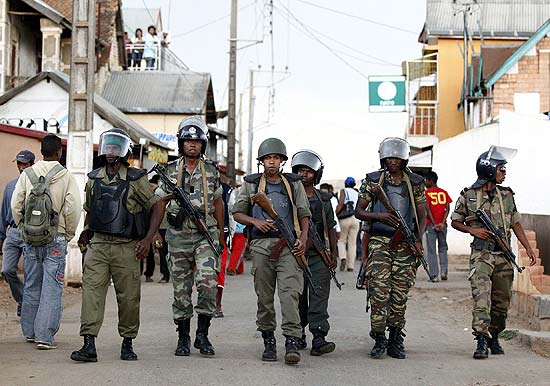 Soldados patrulham a rua depois de dispersar multido perto do acampamento de Ivato, onde esto militares dissidentes