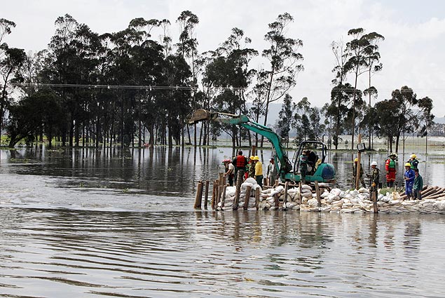 Membros do Exrcito, da Defesa Civil e da polcia tentam construir um dique no rio Bogot