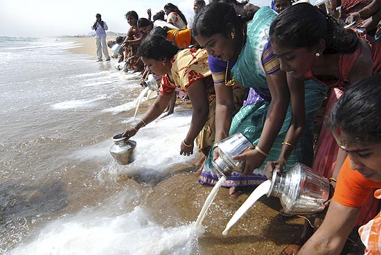 Mulheres jogam leite puro na praia de Marina, em Chennai, um tributo s vtimas do tsunami de 2004