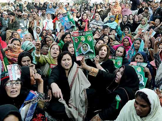 Apoiadores levam fotos da ex-primeira-ministra Benazir Buttho, nos trs anos de seu assassinato