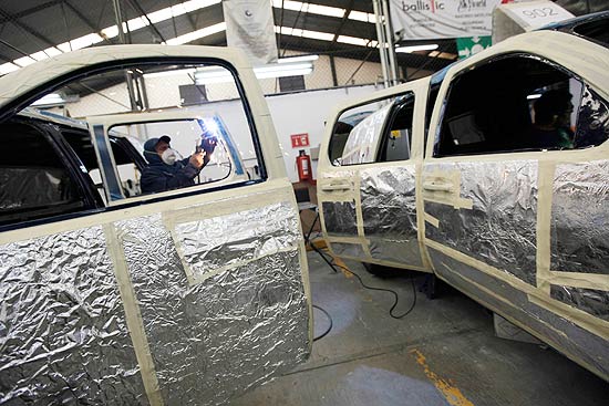 Soldador trabalha em vidros a prova de balas para a porta de um carro, em oficina na Cidade do Mxico