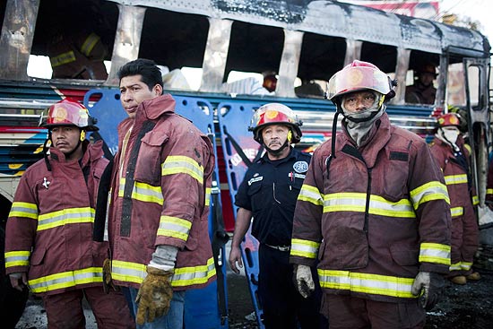 Bombeiros descansam aps apagar as chamas de um nibus cuja exploso matou ao menos quatro passageiros