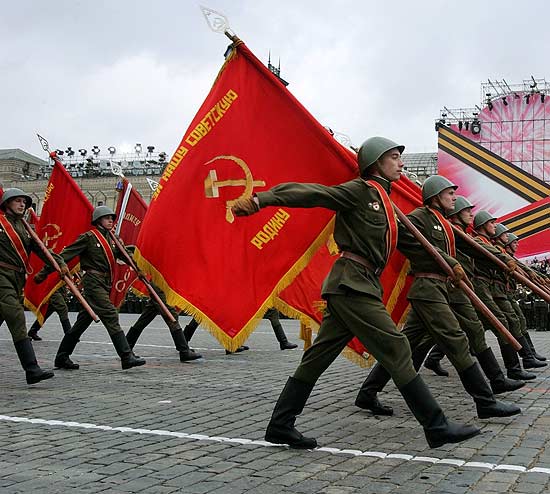 Levando bandeiras do Exrcito Vermelho, russos vestidos com uniformes da URSS na Segunda Guerra marcham na praa Vermelha