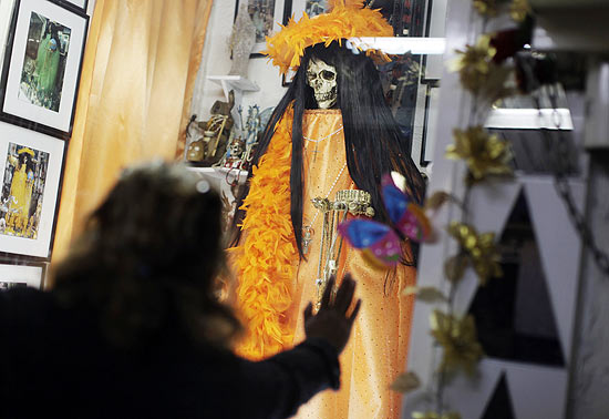 Mulher ora na igreja de La Santa Muerte, em Tepito, no Mxico; seguidores deixaro oferendas em seu altar