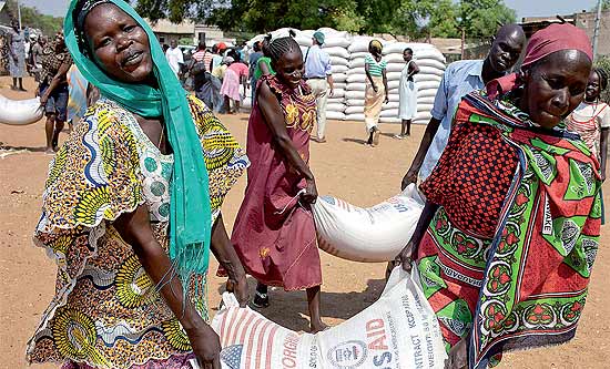 Mulheres carregam sacos de comida doada pela ONU, que investiu US$ 32 milhes para alimentar refugiados do Sudo