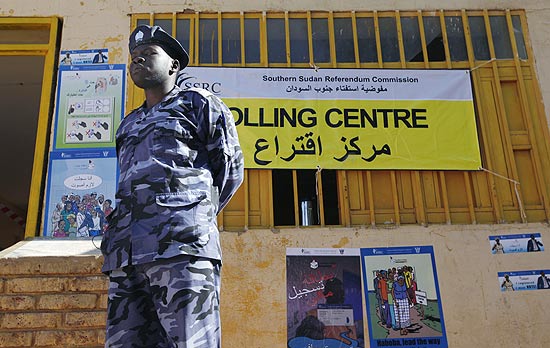 Policial sudans faz guarda na entrada de posto de votao antes do referendo deste domingo