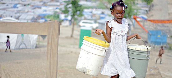 Criana haitiana leva baldes para coletar gua no acampamento de Acra, em Porto Prncipe
