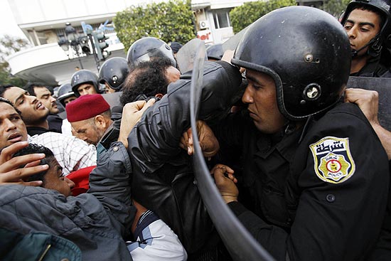 Manifestantantes são empurrados por policiais antidistúrbios em Túnis, capital da Tunísia