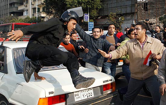 Policial pula viatura em meio aos esforos para conter manifestantes antigoverno no Cairo