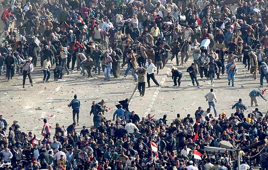 Manifestantes pr-governo (abaixo) enfrentam os egcpios anti-Mubarak na praa Tahrir, no centro do Cairo