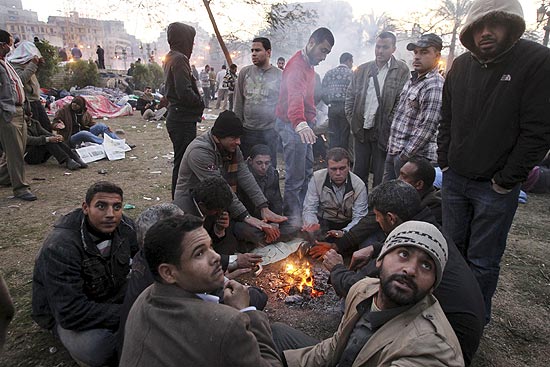 Egpcios se renem em torno de fogueira para resistir a mais uma noite na praa Tahrir em protesto contra Mubarak