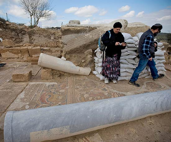 Visitantes observam mosaico em local arqueológico encontrado após perseguição a ladrões