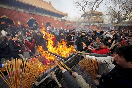 Devotos acedem incenso no Templo Lama, monastrio tibetano fora do Tibete, no incio do Ano Novo em Pequim