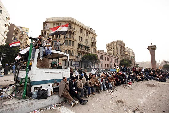 Manifestantes antigoverno aguardam perto de barricada improvisada na praça Tahrir, no Cairo