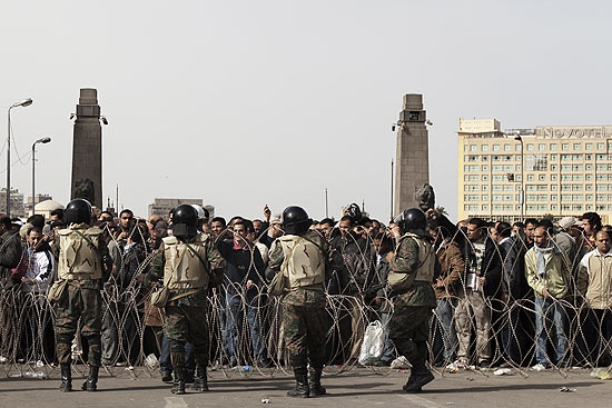Soldados egpcios ficam em guarda atrs de arame farpado em dia de Marcha da Partida no Cairo