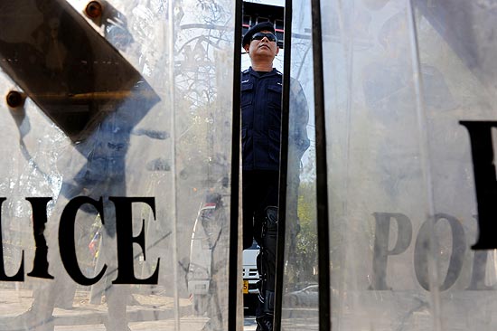 Policial tailands faz guarda atrs de proteo colocado do lado de fora da sede do governo em Bancoc