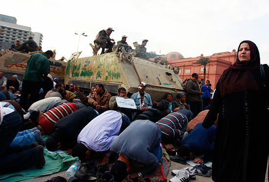 Opositores rezam em frente a tanque militar na praa Tahrir, no Cairo; manifestantes ignoram advertncia