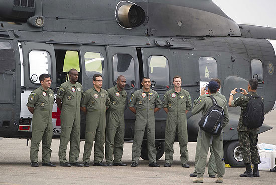 Soldados brasileiros posam em frente ao helicóptero que deve resgatar cinco reféns das Farc até domingo