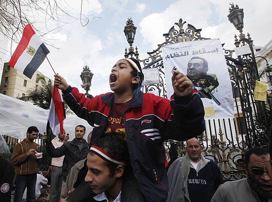 Menino grita frases antigoverno com bandeira do Egito nas mos em frente ao Parlamento do Egito, no Cairo