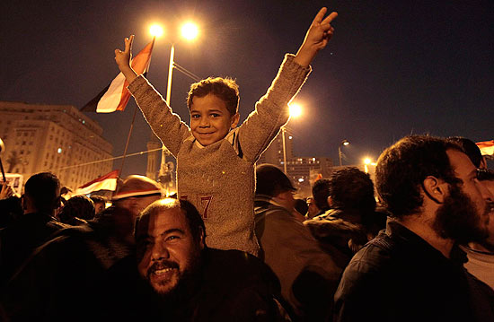Criana levanta os braos em comemorao pela renncia de Mubarak na praa Tahrir, centro do Cairo