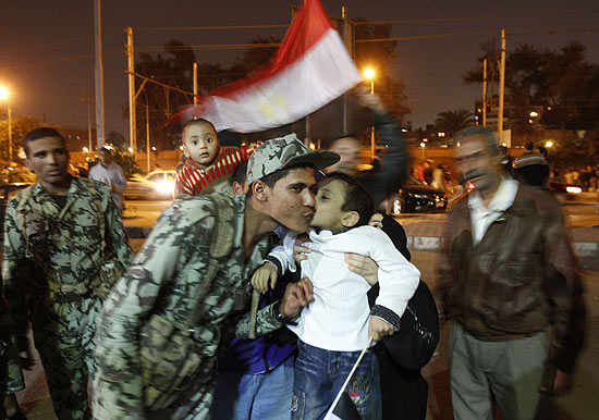 Garoto egpcio beija soldado aps renncia de Mubarak; Suca congela bens de ex-ditador