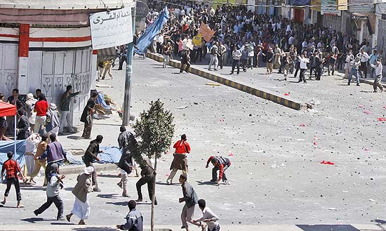Manifestantes antigoverno (no alto) e pr-governistas jogam pedras uns contra os outros nas ruas de Sanaa
