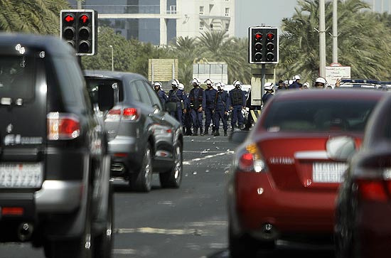 Foras de segurana do Bahrein, ao fundo, fazem guarda na praa Pearl aps a expulso de manifestantes