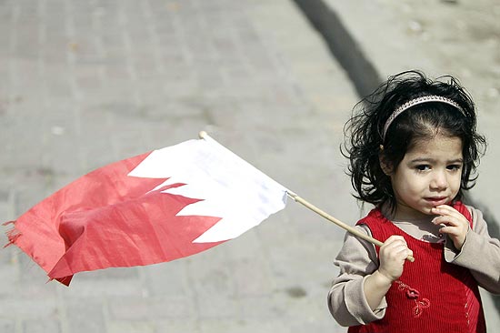 Criana segura bandeira nacional do Bahrein na praa da Prola, centro da capital do pas, Manama