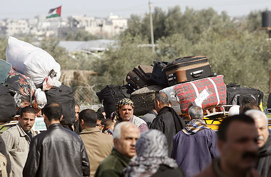 Palestinos aguardam para cruzar fronteira entre Gaza e Rafah, no Egito, que estava fechada desde revolta 