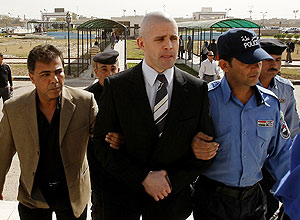O britnico Danny Fitzimons (centro) chega a tribunal em Bagd, capital do Iraque, cercado por policiais