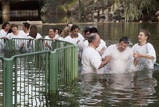 Grupo de 25 dos 33 mineiros chilenos resgatados no ano passado após 69 dias foi batizado no rio Jordão