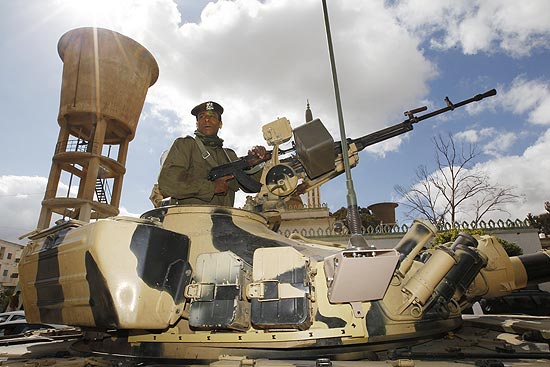 Tanque militar vigia intersecção no subúrbio de Trípoli; forças americanas se mobilizam na costa da Líbia