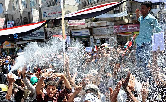 Manifestantes usam sprays de espuma durante uma manifestao convocada pela oposio em Sanaa, Imen