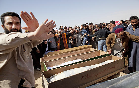 Lbios renem-se ao lado dos caixes de rebeldes mortos por tropas de Gaddafi na cidade de Ajdabiya
