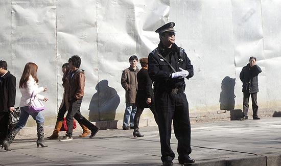 Policial faz guarda perto do distrito de Xidan, para onde estavam previstos protestos em Pequim