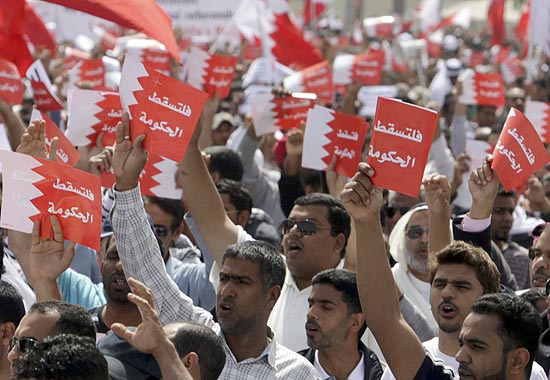 Milhares de pessoas gritam slogans antigoverno com cartazes onde se l: "Abaixo ao governo" em Manama