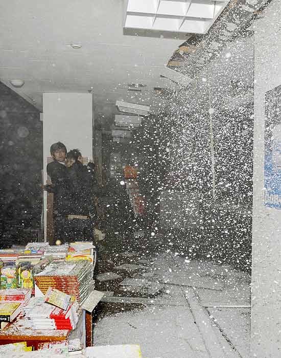 Pessoas se protegem quando telhado começa a desmoronar em livraria em Sendai; há cerca de 200 corpos na cidade