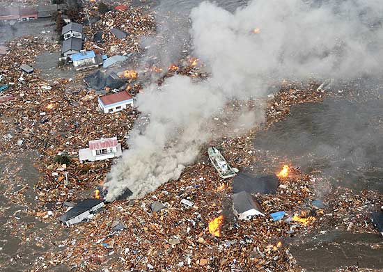 Reprodução de imagem de TV mostra tsunami devastando a área costeira da cidade de Sendai, no Japão