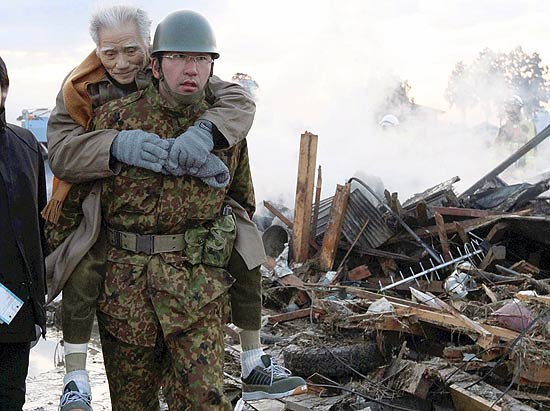 Membro de equipes de resgate carrega um idoso na cidade de Miyagi, uma das mais atingidas pelo tsunami