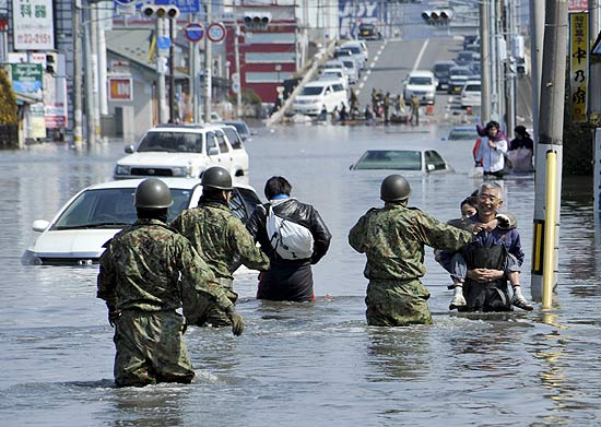Forças de Autodefesa Japão ajudam no trabalho de evacuação de moradores da cidade de Ishinomaki, em Miyagi