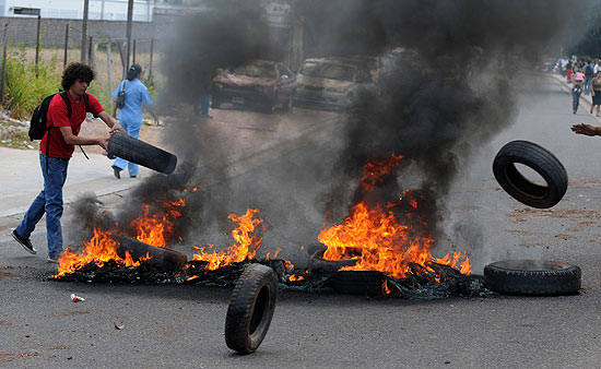 Professores hondurenhos em greve montam barricada com pneus em chamas em via da capital, Tegucigalpa