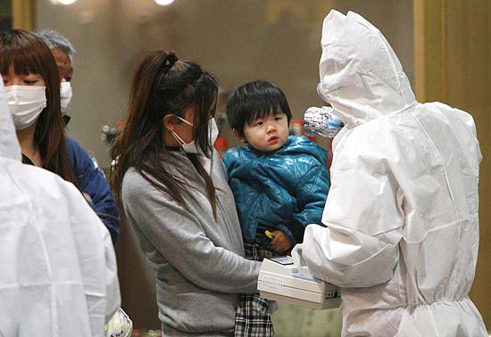 Criança é testada para atestar exposição à radiação em Koriyama, na região de Fukushima; brasileiros são retirados