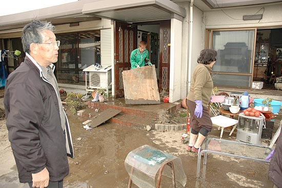 Familia Hara limpa lama que invadiu sua casa em Sendai, cidade mais afetada pelo tremor de sexta (12)